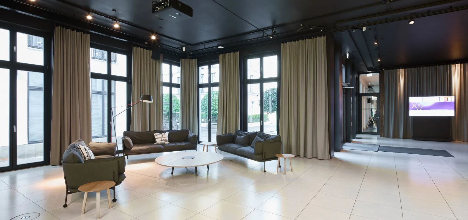 Moderne Lounge mit eleganten Sofas und großen Fenstern im Haus A, Büroflächen Westend Ottensen, Hamburg.